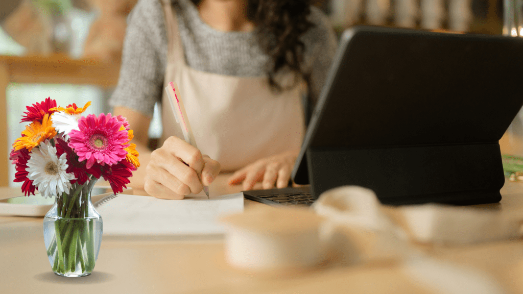 Employee at a desk surrounded by flowers, illustrating onboarding in the floral industry