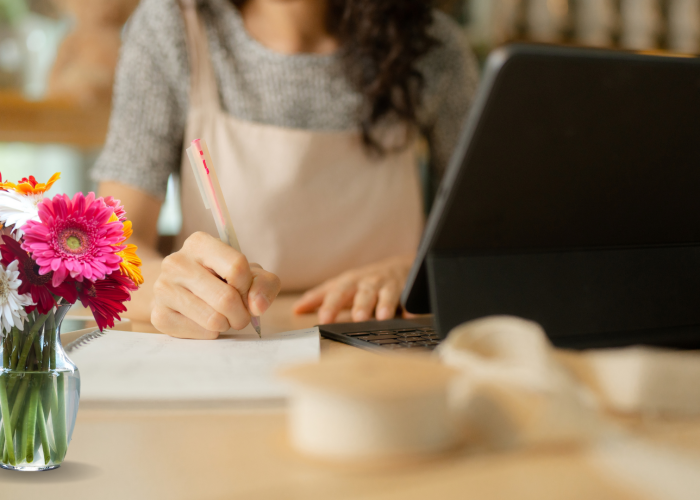 Employee at a desk surrounded by flowers, illustrating onboarding in the floral industry